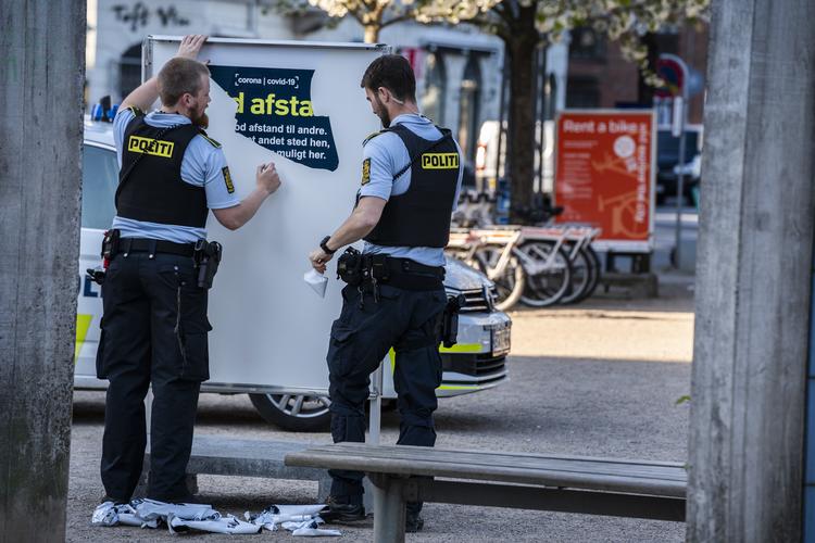 Politi fjerner skiltene med opfordring til at holde stand til fordel for 'ophold forbudt'-skilte på Islands Brygge i København. Foto: Martin Sylvest/Ritzau Scanpix