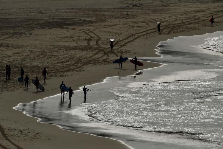 Surfere er tilbage ved Bondi Beach. Den er genåbnet tirsdag efter fem ugers nedlukning.   Foto: Saeed Khan/Ritzau Scanpix