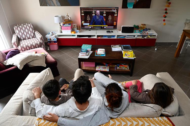     Millioner af franskmænd, her en karantæneramt familie, fulgte premierminister Edouard Philippes tale. Landet lukker meget forsigtigt op 11. maj - men betingelsen er, at virussen er under kontrol. Også efter 11. maj kulturlivet, restauranter og cafeer lukket ned minimalt frem til 2. juni.   Foto: Damien Meyer/Ritzau Scanpix