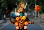 Flere steder i Indien kan man se advarsler mod covid-19. På billedet er en mand klædt ud som Yama - den hinduistiske dødsgud - med forskellige covid-19 balloner for at advare befolkningen i New Delhi. Foto: Adnan Abidi/Ritzau Scanpix
