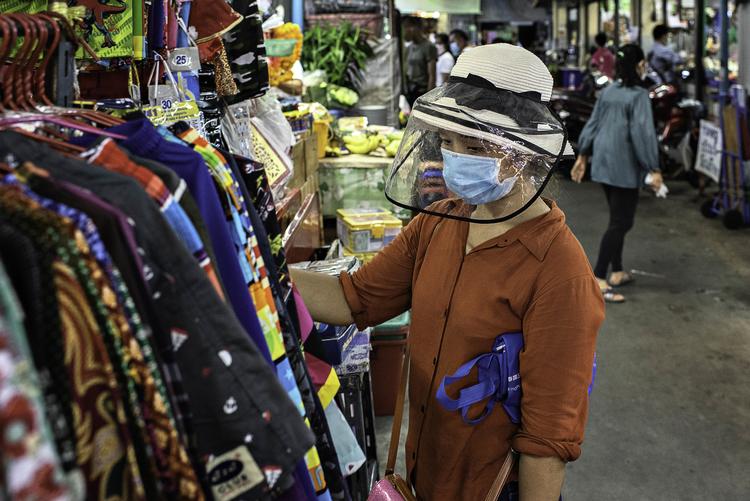 En kvinde ser på tøj på et marked i Bangkok, hvor der er ved at komme en forsigtig tro på, at det værste måske snart er ovre. Foto: Claus Blok Thomsen