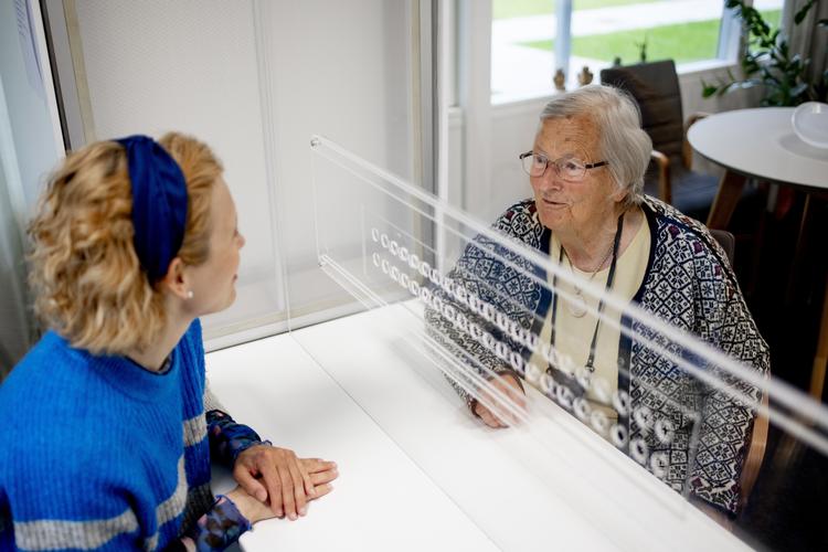 Tornbjerg Friplejehjem benytter en 'samtaleboks', som sikrer beboerne mod coronasmitte, når de har besøg. På billedet tester en beboer samt forstander Christine Wille boksen.   Foto: Christian Nordholt/Ritzau Scanpix