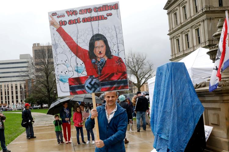 Donald Trump har Gretchen Whitmer har kaldt hende en »halvhjerne«, og højreorienterede demonstranter fremstillede hende som Hitler ved en demonstration i går i Michigan.  Foto: Jeff Kowalsky/Ritzau Scanpix