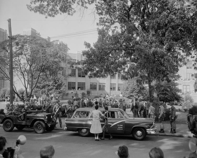 Skoler og meget andet var opdelt i USAs sydstater og der var stor modstand mod at droppe det. Her ses soldater beskytte sorte elever på et gymnasium i Little Rock Arkansas i 1957. Foto: Rwt/AP