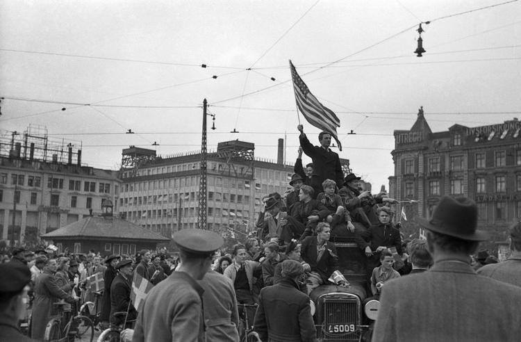 Folk på gaden i København fejrer befrielsen i 1945 og vifter med det amerikanske flag.   Foto: Erik Petersen/POLFOTO