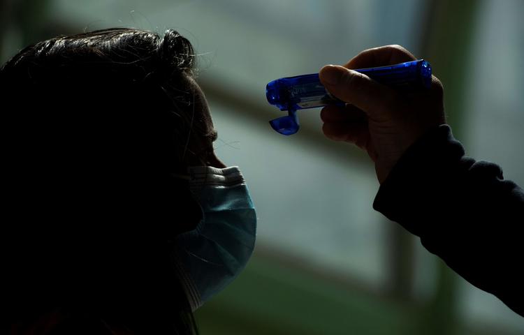 En medicinsk medarbejder tager en persons kropstemperatur, da hun ankommer til Tor Vergata Covid hospital i Rom.   Foto: Tiziana Fabi/Ritzau Scanpix