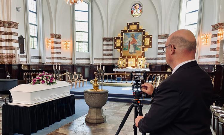 Bedemand Bo Holtenbang fra Begravelses Service indstiller kameraet i Filip Kirken på Amager. Under ceremonien kan han styre streamingen fra våbenhuset.  Foto: Carsten Mandalay, Begravelses Service 