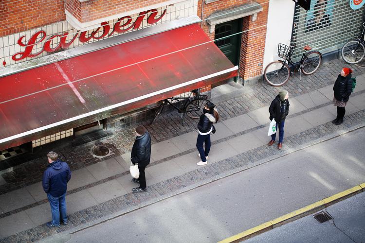 Sundhedsstyrelsen ændrede søndag anbefalingen om af holde afstand fra 2 meter til 1 meter. Her står mennesker i kø til en butik på Amager.  Foto: Thomas Borberg/POLFOTO