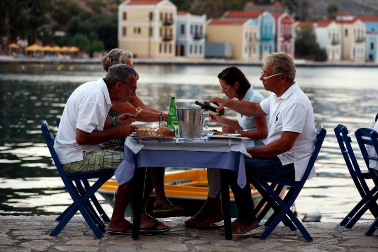 People eat at a restaurant in the village of Meyisti on the Island of Kastellorizo which is the most easterly of the islands in Greece, July 4, 2015. It was on this island, that former Prime Minister George Papandreou announced in 2010 that Greece required a rescue package. If a 'No' in Sunday's referendum eventually takes Greece out of Europe's single currency, any "new drachma" or temporary payment unit could be worth as little as a fifth of the euro now in circulation. REUTERS/Cathal McNaughton Foto: Cathal Mcnaughton/Ritzau Scanpix