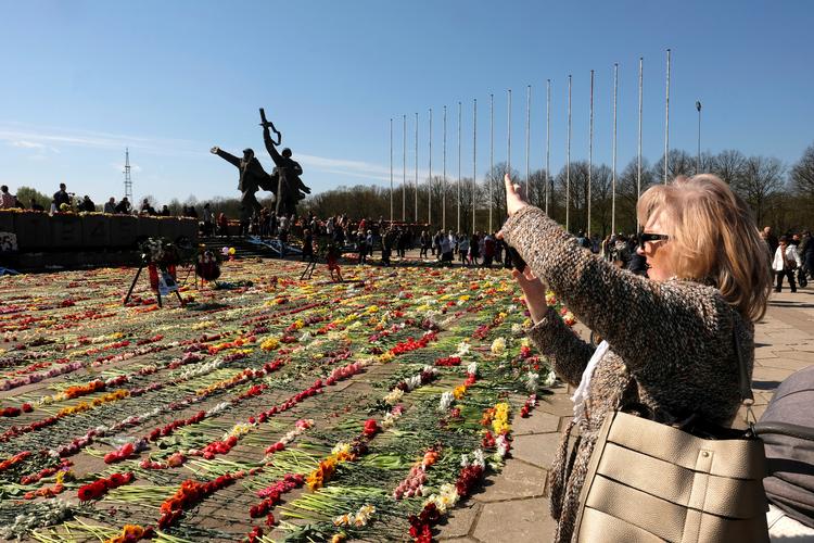 En kvinde tager et billede ved et mindesmærke i Letlands hovedstad, Riga på 75 året for afslutningen på Anden Verdenskrig. Foto: Ints Kalnins/Ritzau Scanpix