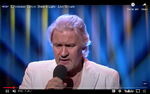 Irske Johnny Logaan har som den eneste vundet det internationale melodigrandprix to gange og derfor spillede han med guldsko und alles en central rolle i ESC Shine A Light-showet lørdag aften.  Foto: Skærmdump fra udsendelsen. 
