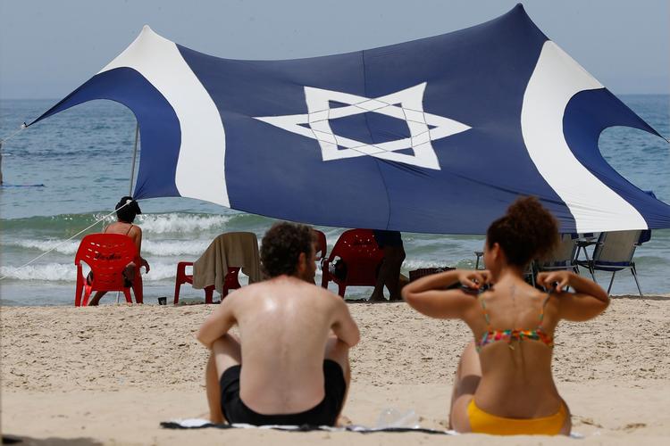 Temperaturerne er høje i Israel lige nu, og folk benyttede sig af fridagen til en tur til stranden i kystbyen Tel Aviv lørdag. Politikerne har brugt tiden anderledes - søndag har landets premierminister Netanyahu præsenteret sin nye regering for parlamentet. Foto: Jack Guez/Ritzau Scanpix