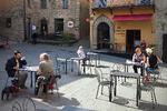 Normalt er der langt flere borde og stole på den lille piazza i Montone, Umbrien. Men kravene til afstand mellem borde har mere end halveret pladserne.  