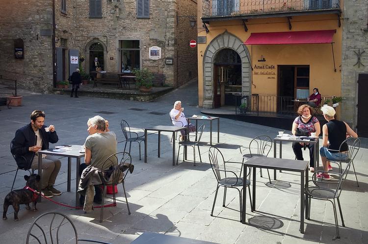 Normalt er der langt flere borde og stole på den lille piazza i Montone, Umbrien. Men kravene til afstand mellem borde har mere end halveret pladserne.  
