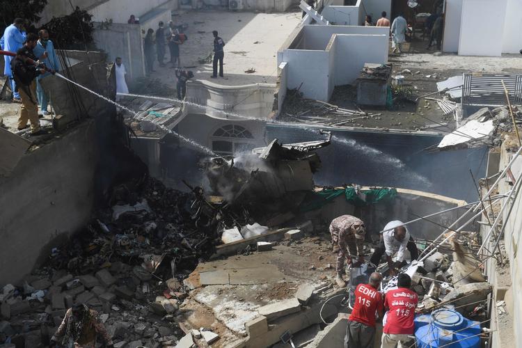 Politi og hjælpearbejdere arbejder på stedet, hvor et passagerfly faldt ned i et beboelsesområde i Karachi, Pakistan. Foto: Asif Hassan/Ritzau Scanpix