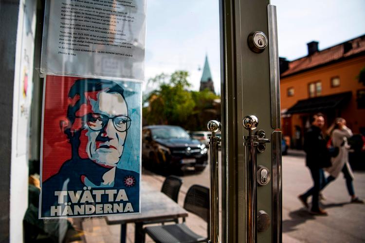  Et plakat med ansigtet af Anders Tegnell, der er blevet symbolet på den svenske coronakurs, hænger ved indgangen til en restaurant for at minde folk om at vaske hænder.   Foto: Jonathan Nackstrand/Ritzau Scanpix