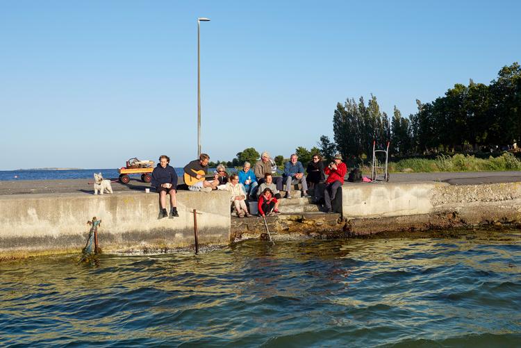 Når vejret og stemningen er til det samles beboere og turister til molekaffe, sang og musik i den lille havn på Bjørnø syd for Faaborg. Foto: Morten Langkilde