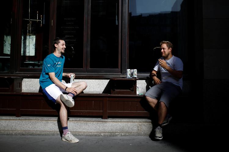 To venner nyder en drink på en varm dag i London. Premierminister Boris Johnson har varslet en lempelse af en række restriktioner. Foto: Henry Nicholls/Ritzau Scanpix