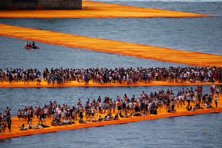Ved Iseo-søen i Italien blev broerne pakket ind i 70.000 kvadratmeter gult stof i 2016. Værket blev kaldt 'The Floating Piers' og blev et af Christos sidste værker.  Foto: Wolfgang Rattay/Ritzau Scanpix