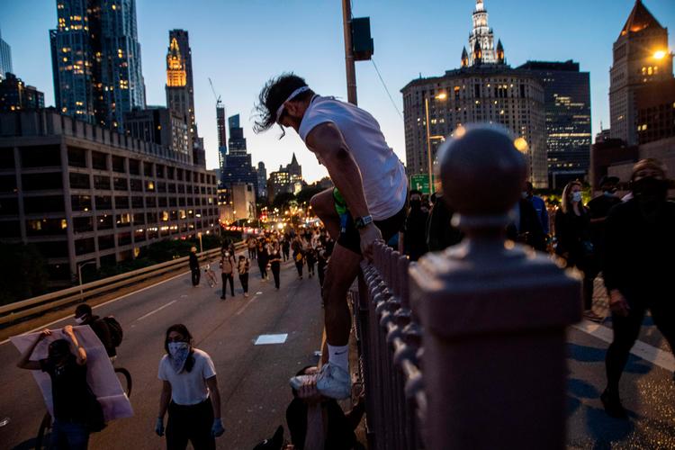 NEW YORK, NEW YORK - MAY 31: A protester climbs down onto traffic lanes of the Brooklyn Bridge during a march to honor George Floyd in Manhattan on May 31, 2020 in New York City. Protesters demonstrated for the fourth straight night after video emerged of a Minneapolis police officer, Derek Chauvin, pinning George Floyd's neck to the ground. Floyd was later pronounced dead while in police custody after being transported to Hennepin County Medical Center. The four officers involved have been fired and Chauvin has been arrested and charged with 3rd degree murder. John Moore/Getty Images/AFP == FOR NEWSPAPERS, INTERNET, TELCOS &amp; TELEVISION USE ONLY == Foto: John Moore/Ritzau Scanpix