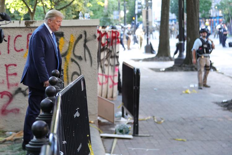 Trump går fra Det Hvide Hus til kirken St. John's Church for at blive fotograferet. Kort forinden er området blevet ryddet for demonstranter med tåregas. Foto: Tom Brenner/Ritzau Scanpix