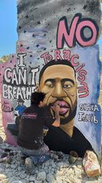 Kunstneren Artist Aziz Asmr arbejder i Idlib i Syrien på et graffitiværk, der forestiller George Floyd Foto: Mohamad Jamalo/Ritzau Scanpix
