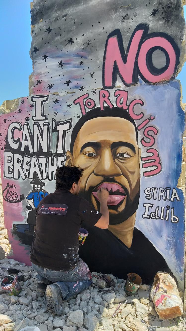 Kunstneren Artist Aziz Asmr arbejder i Idlib i Syrien på et graffitiværk, der forestiller George Floyd Foto: Mohamad Jamalo/Ritzau Scanpix