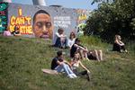 I Mauer Park i Berlin sidder folk foran et portræt af George Floyd, som døde i forbindelse med en anholdelse i USA i sidste uge.  Foto: Odd Andersen/Ritzau Scanpix