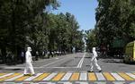 Sundhedspersonale krydser en gade i Almaty, Kazakhstan. Coronavirus er i hele verden, og faren er ikke overstået, før virusset ikke længere findes, siger Verdenssundhedsorganisationen (WHO). Foto: Pavel Mikheyev/Ritzau Scanpix