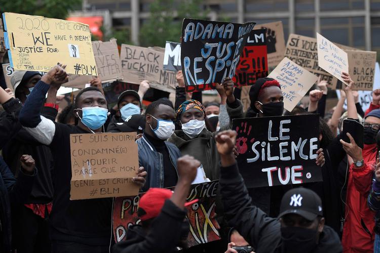 'Tavsheden dræber', står det på et skilt båret af  unge under en demonstration i Strasbourg fredag mod politivold. Nu tager kendte sportsfolk også ordet.   Foto: Frederick Florin/Ritzau Scanpix