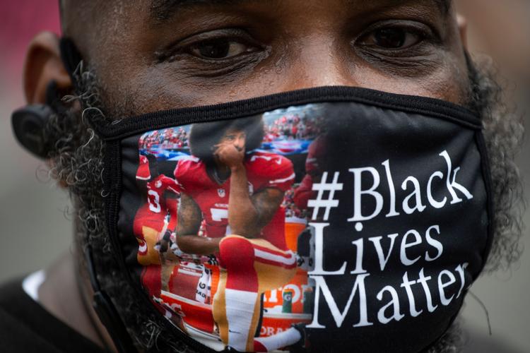 Colin Kaepernicks knælende position er blevet billedet på den tavse og fredelig protest mod racisme og politivold i USA. Foto: Roberto Schmidt/Ritzau Scanpix