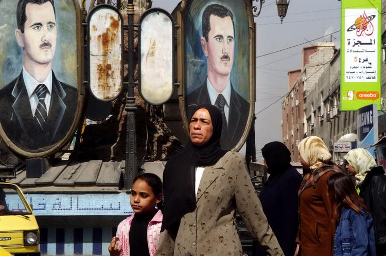  Syrere under vægbannere med diktatoren Bashar al-Assad. Kan han skabe tillid til sit styre efter borgerkrigen? Det testes i byen Suwayda.  Arkivfoto. Foto: Amr Nabil