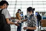 En lufthavnsmedarbejder tjekker temperaturen på en rejsende i boardingområdet i Tianhe Lufthavn i Wuhan. Landet advarer nu rejsende at tage til Australien. Foto: Hector Retamal/Ritzau Scanpix
