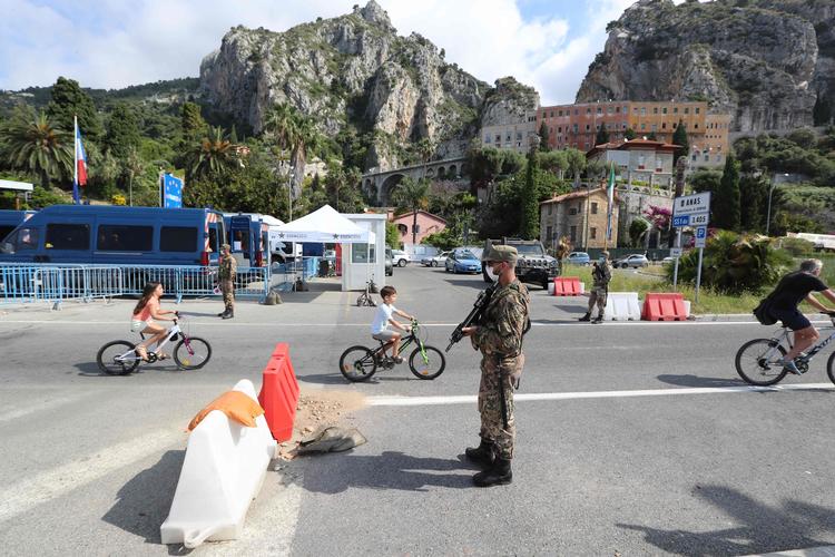 Cyklister passerer den fransk-italienske grænse nær Menton 3. juni, hvor Italien åbnede sin grænse efter tre måneders nedlukning som følge af corona.  Foto: Valery Hache/Ritzau Scanpix