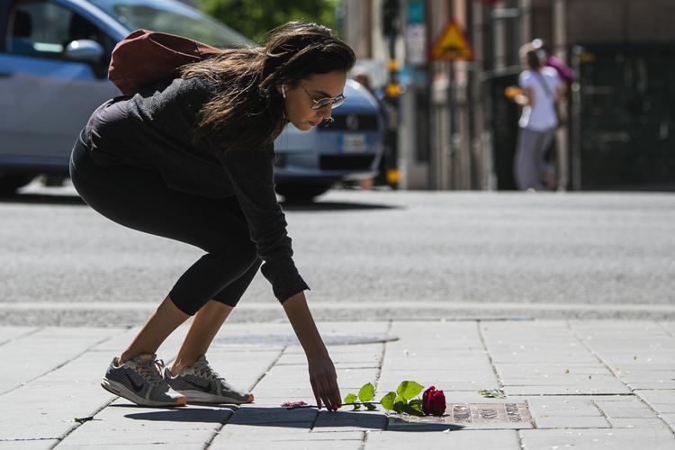 En svensker lægger en rose ved den mindeplade, der markerer stedet, hvor statsminister Olof Palme blev skidt 28. februar  1986 i det centrale Stockholm. Foto: Jonathan Nackstrand/Ritzau Scanpix