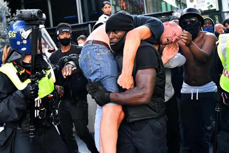 Fotoet har af åbenlyse grunde fået særlig opmærksomhed. »Elsk dine medmennesker. Vi er alle samme race«, lød det blandt andet fra redningsmanden dagen efter. Foto: Dylan Martinez/Ritzau Scanpix
