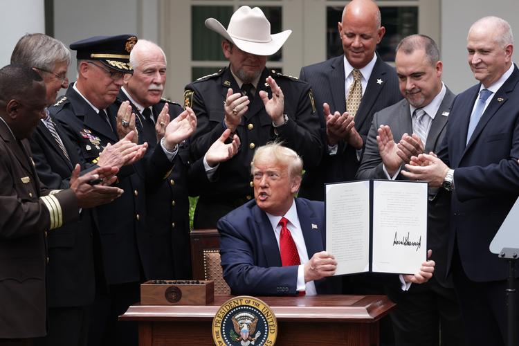     WASHINGTON, DC - JUNE 16: Surrounded by members of law enforcement, U.S. President Donald Trump holds up an executive order he signed on Safe Policing for Safe Communities during an event in the Rose Garden at the White House June 16, 2020 in Washington, DC. President Trump signed an executive order on police reform amid the growing calls after the death of George Floyd. Alex Wong/Getty Images/AFP == FOR NEWSPAPERS, INTERNET, TELCOS &amp; TELEVISION USE ONLY ==   Foto: Alex Wong/Ritzau Scanpix