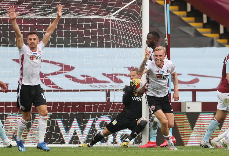 Sheffield United-spillerne er sikre på, der er mål til dem, mens Aston Villas norske målmand Ørjan Nyland ser nervøst til fra baggrunden.  Foto: Carl Recine/Ritzau Scanpix