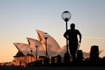 Sydney Opera House i solnedgangen med en løber i forgrunden. Og australierne kan forvente, at få turistikoner som operahuset for sig selv den næste lange tid. Landet vil formentlig ikke sige velkommen til turister før i 2021. Foto: Saeed Khan/Ritzau Scanpix