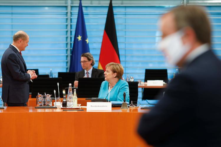 Den tyske kansler, Angela Merkel, taler med to af sine ministre. Smitten stiger enkelte steder i landet, hvilket får det såkaldte kontakttal til at stige fra 1,06 til 1,79. Foto: Markus Schreiber/Ritzau Scanpix