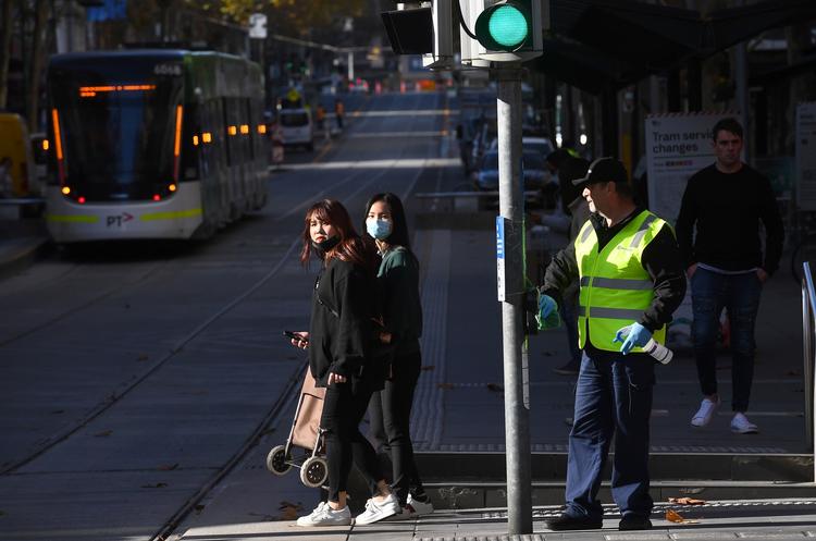 En mand desinficerer på gaden i Melbournes centrale forretningsområde. Byen frygter anden bølge af coronavirus. Foto: William West/Ritzau Scanpix