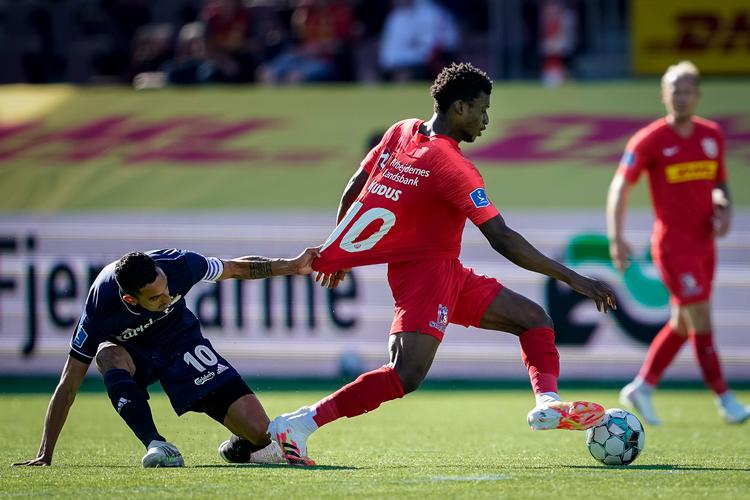 FC Nordsjællands 19-årige ghanesiske spiller Mohammed Kudus (i rødt) er ikke nem at stoppe, men FC Københavns Carlos Zeca gør et alt-eller-intet-forsøg i denne duel. Kudus er med til at gøre sin danske klub til den bedst spillende i Superligaen. Foto: Niels Christian Vilmann/Ritzau Scanpix