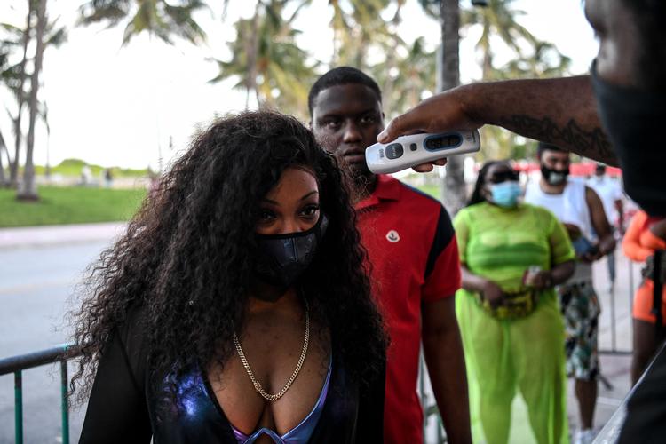En kvinde får tjekket sin temperatur, inden hun skal besøge en restaurant i Florida, hvor antallet af nye coronasmittede nærmest dagligt sætter rekord.   Foto: Chandan Khanna/Ritzau Scanpix
