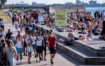 Svenskere flokkes om pladserne ved vandet i Malmø på en varm dag, samtidig med at skilte skal minde dem om at holde afstand. Forskere i Danmark har skabt et overblik over, hvordan coronasmitten har spredt sig ind og ud af Danmark - blandt andet til Sverige. Foto: Tt News Agency/Ritzau Scanpix