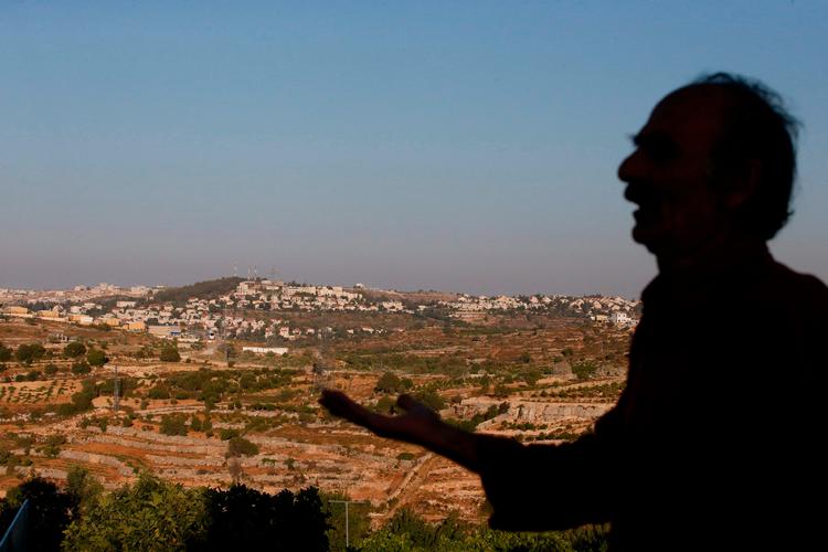 Palæstinenser gestikulerer i landsbyen Khirbeet Zakarya - i baggrunden den israelske bosættelse Efrata.  Foto: Hazem Bader/Ritzau Scanpix