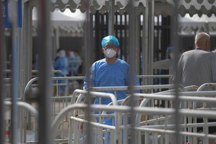 En sundhedsmedarbejder iklædt værnemidler venter ved et  COVID-19-testcenter i Beijing. Mens verden lige nu kæmper med coronavirus, er der fundet et nyt virus i landet.    Foto: Greg Baker/Ritzau Scanpix