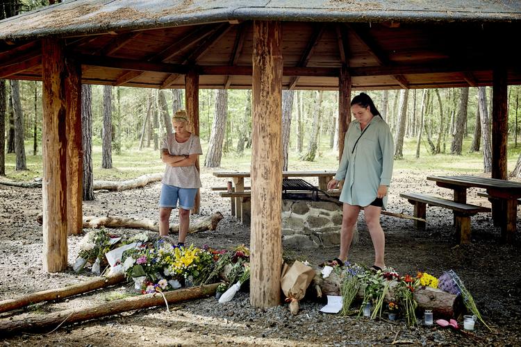     Shelter i Nordskoven ved Haslevej i Rønne på Bornholm, mandag den 29. juni 2020. En 28-årig mand, med afrikanske rødder, fra Sjælland blev tirsdag den 24. juni fundet dræbt ved shelterpladsen. Han var blevet ramt af slag med rafter, flasker og knytnæver og af flere knivstik. Michella og Bella, som kendte den dræbte og har gået på Klemensker Skole med ham, lægger blomster på gerningstedet.. (Foto: Pelle Rink/Ritzau Scanpix)   Foto: Pelle Rink/Ritzau Scanpix
