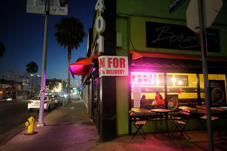   Ansatte samles udenfor en restaurant i Los Angeles. Guvernør Gavin Newsom besluttede onsdag at lukke indendørs servering i byens restauranter i de næste tre uger. Andre dele af staten er også omfattet, og andre forholdsregler mod coronaen er på vej i USA's folkerigeste stat. Foto: Mario Tama/Ritzau Scanpix