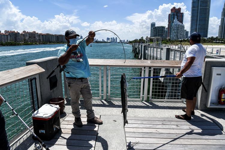 En fisker i Miami i Florida bærer maske. Florida er blandt de hårdest ramte stater af corona. Foto: Chandan Khanna/Ritzau Scanpix
