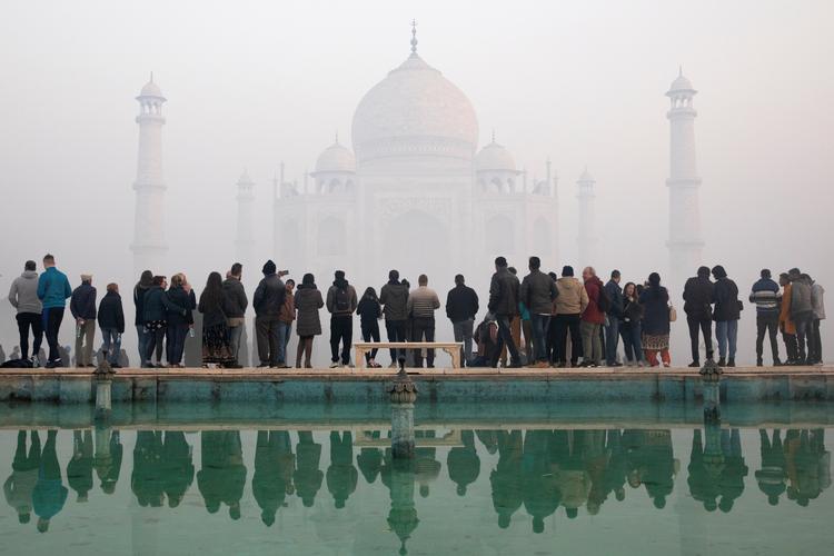 Besøgende ved Taj Mahal i januar sidste år. Tågen er ikke tåge, men smog fra forurening.  Foto: Andrew Kelly/Ritzau Scanpix